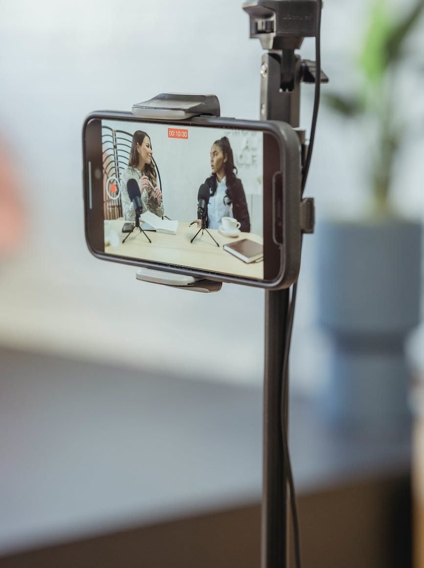 smartphone on tripod recording vlog with young multiethnic ladies