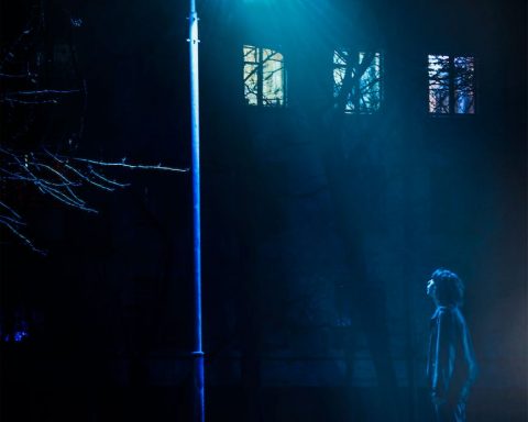 man standing in front of street light turned on
