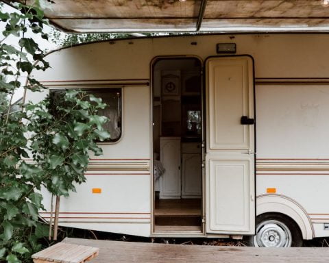 a skateboard on wooden deck near a white caravan