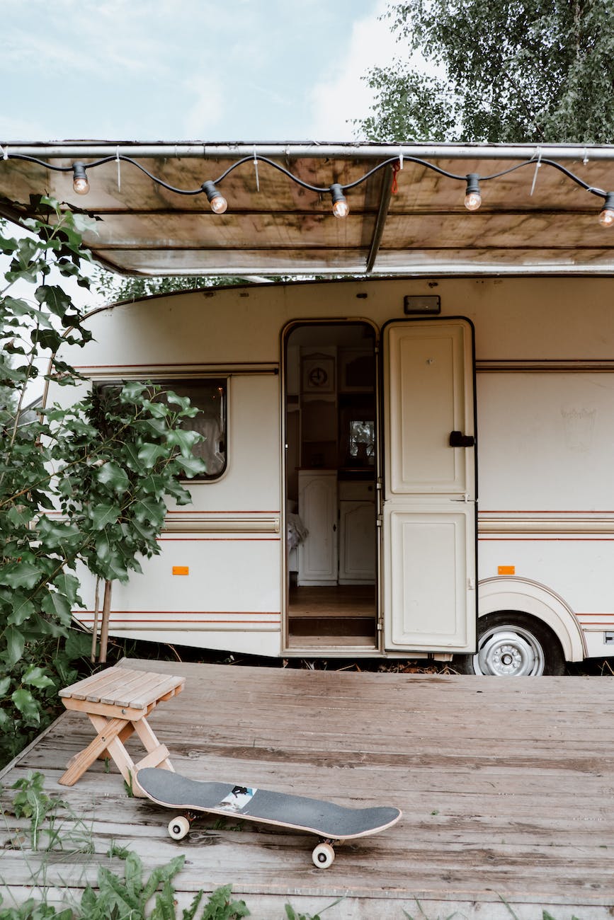 a skateboard on wooden deck near a white caravan