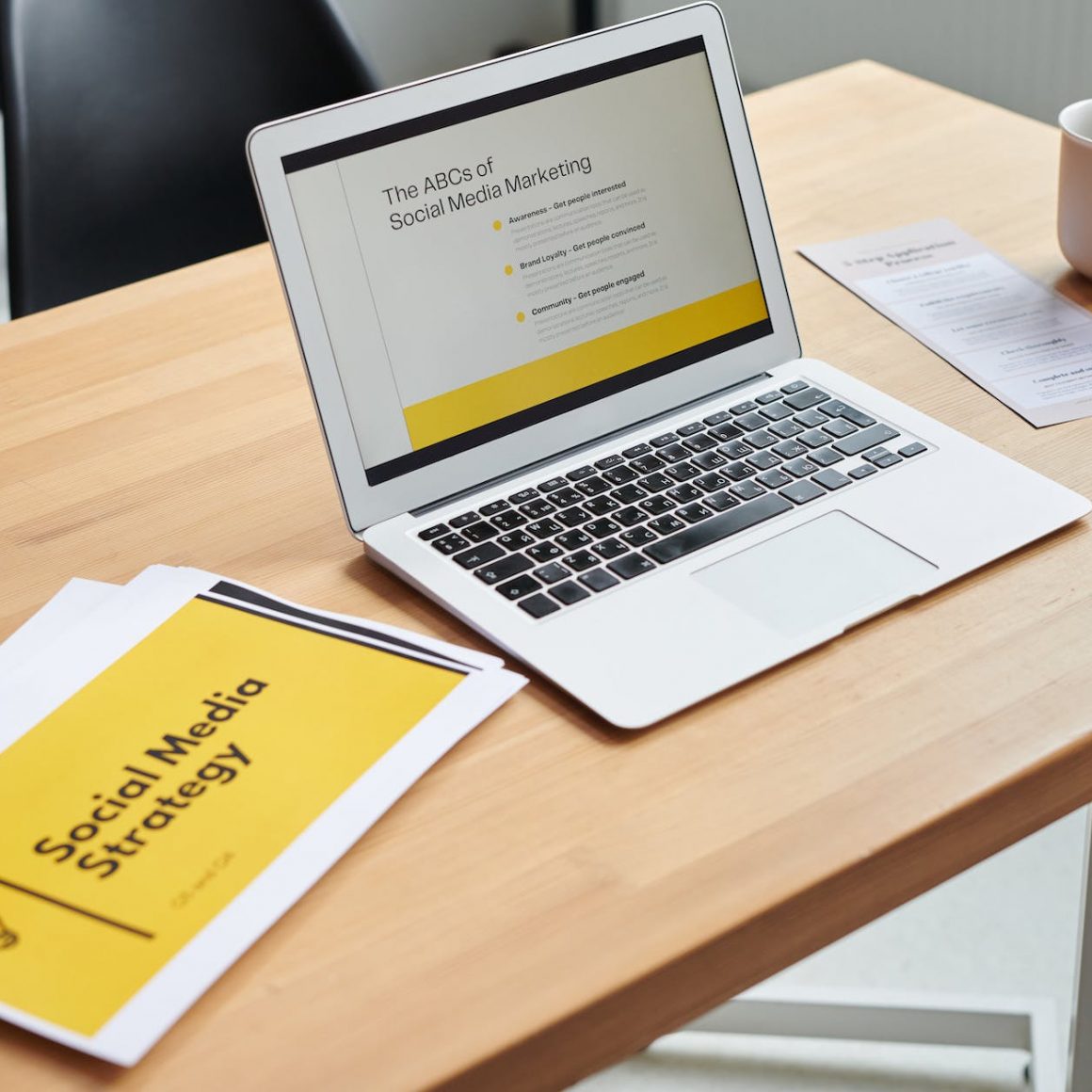 close up shot of a laptop beside paper documents