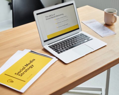 close up shot of a laptop beside paper documents
