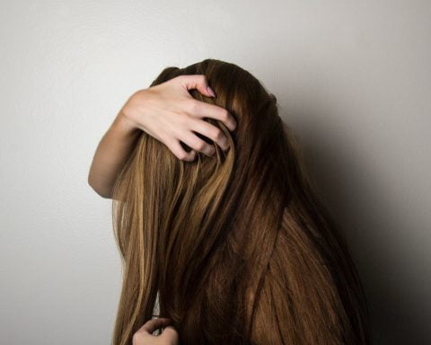 photo of woman covering face with her hair