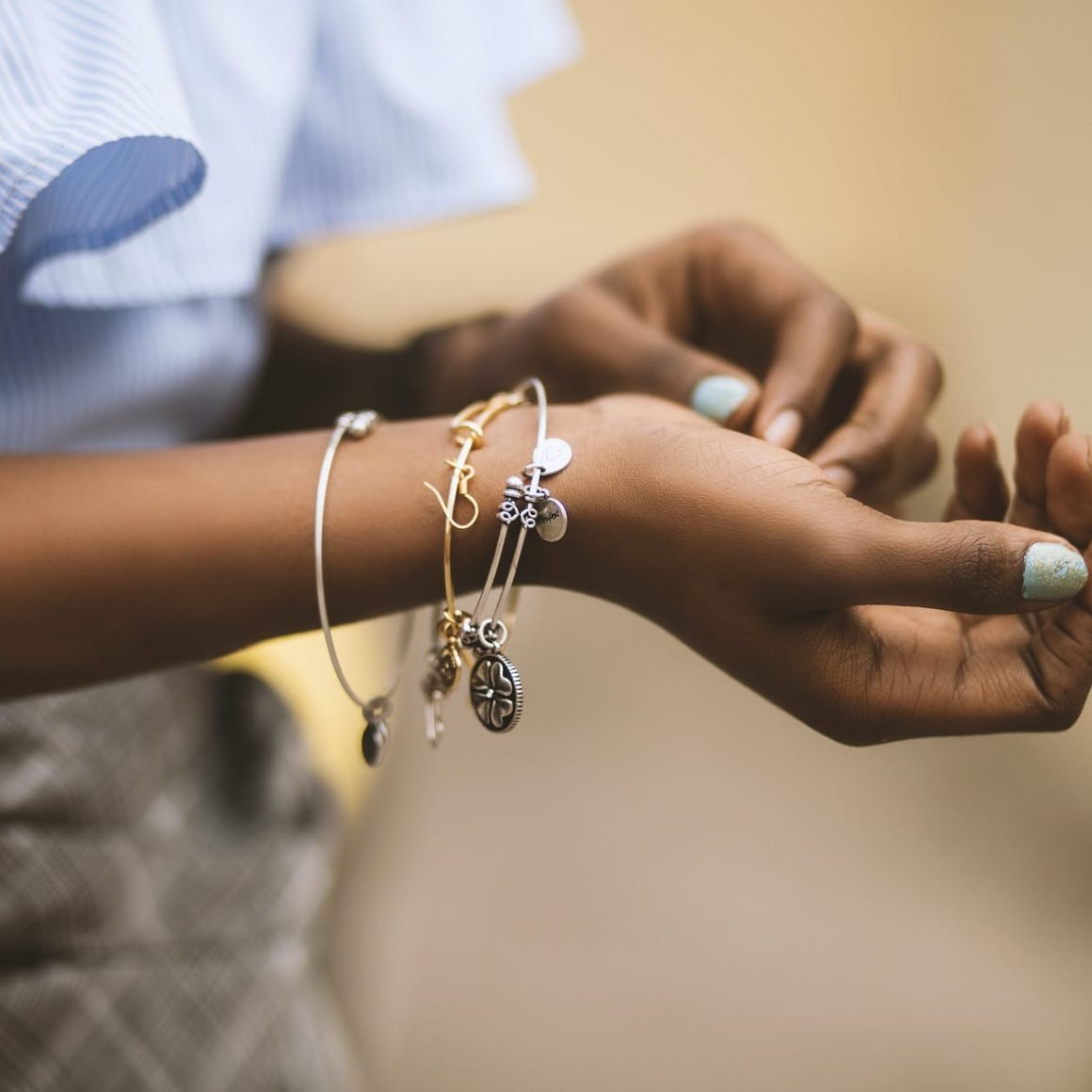 selective focus photography of person wearing three bangles