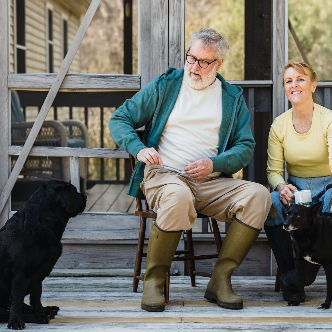 spouses sitting on terrace with dogs