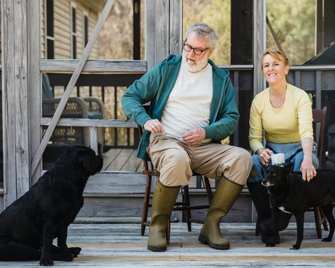 spouses sitting on terrace with dogs
