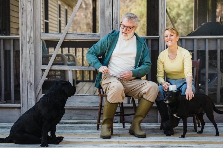 spouses sitting on terrace with dogs