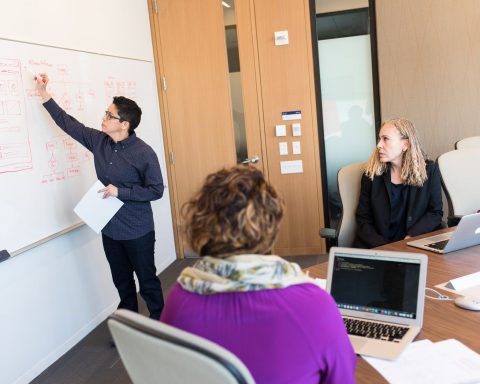 man wearing black button up long sleeved writing of board