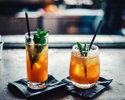two brown liquid inside clear drinking glasses