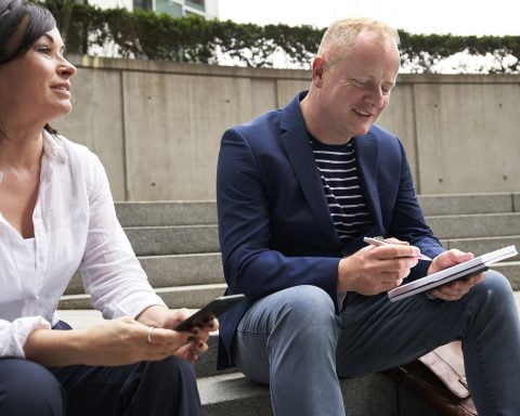 woman and man having a discussion while sitting on steps