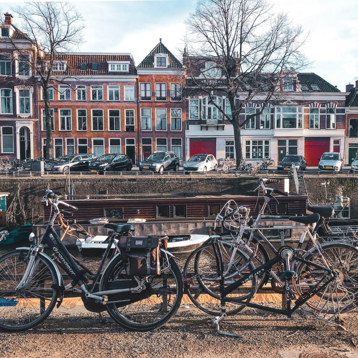 bicycles parked beside brown wooden fence near a river