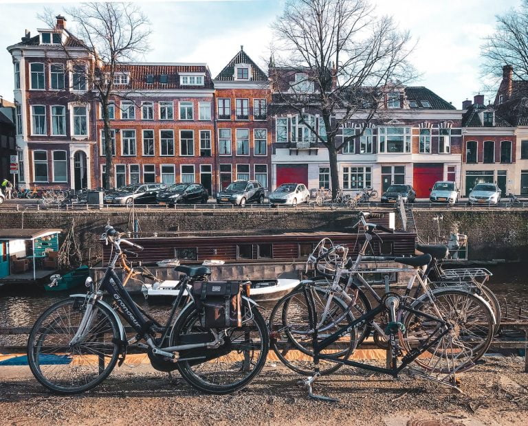 bicycles parked beside brown wooden fence near a river