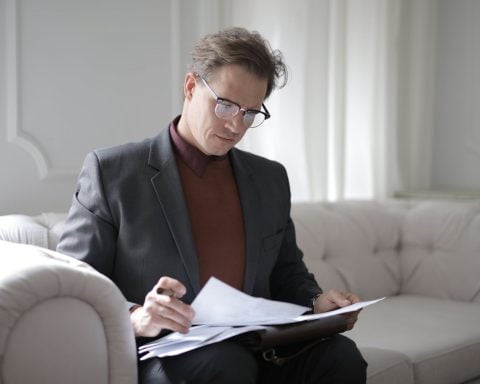 classy executive male reading papers on couch