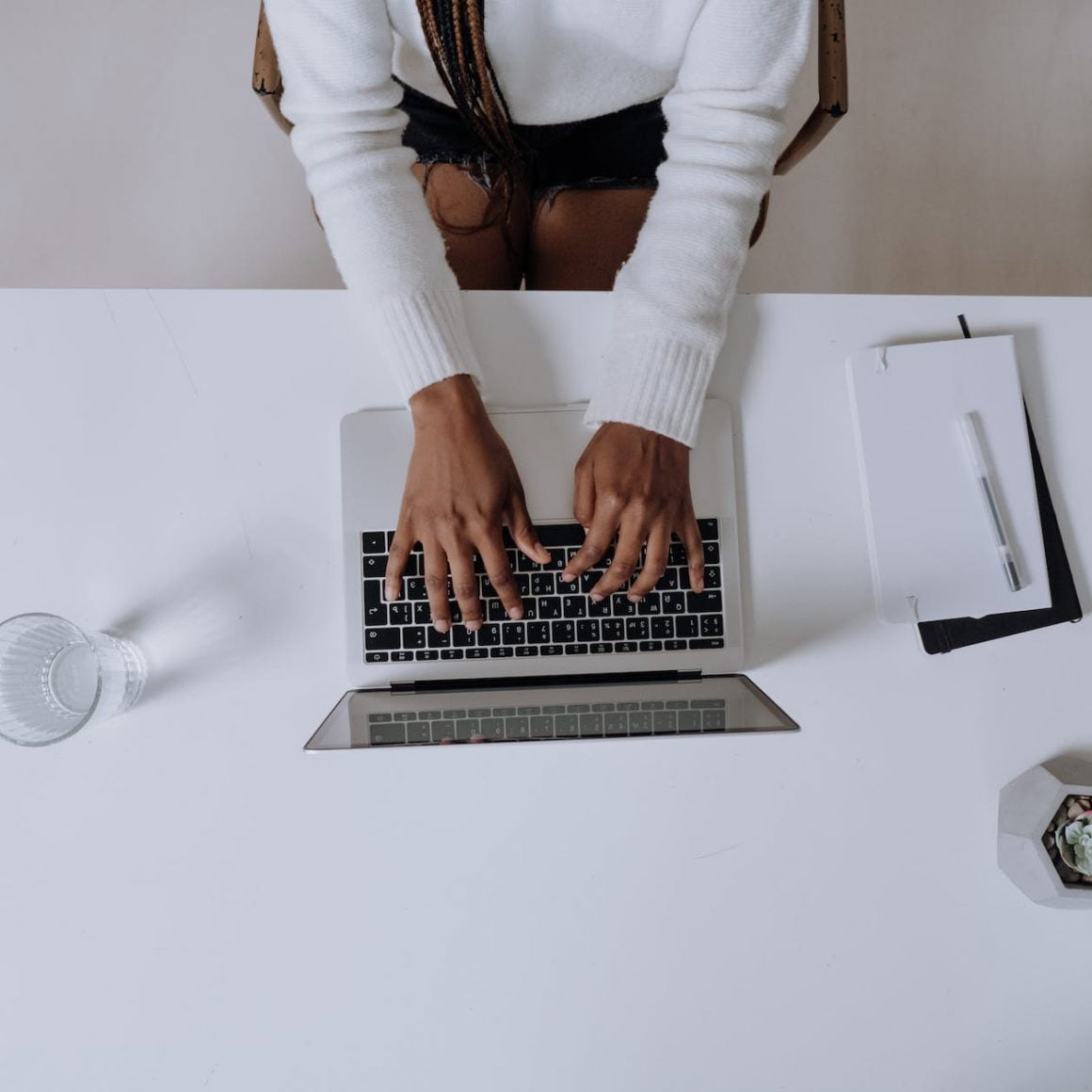 woman in white long sleeve shirt using macbook pro
