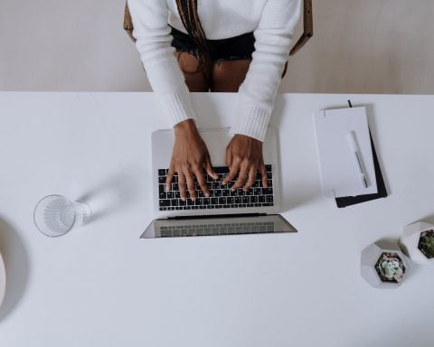 woman in white long sleeve shirt using macbook pro