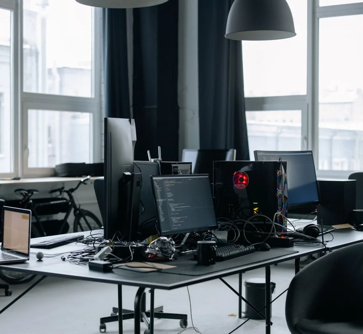 Werkplek met computerschermen vol code, symbool voor techbedrijf i3D.net